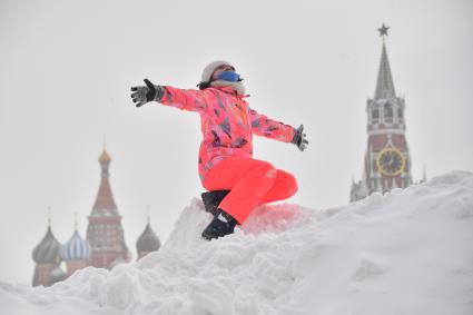 Москва. Девочка играет на снежной горке на Красной площади