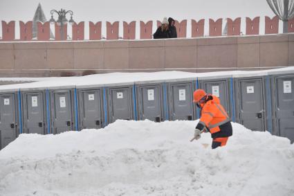 Москва. Сотрудник коммунальных служб расчищает снег в центре города.