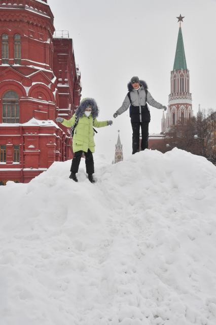 Москва. Дети играют на снежной горке на Манежной площади.