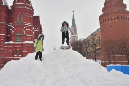 Москва. Дети играют на снежной горке на Манежной площади.