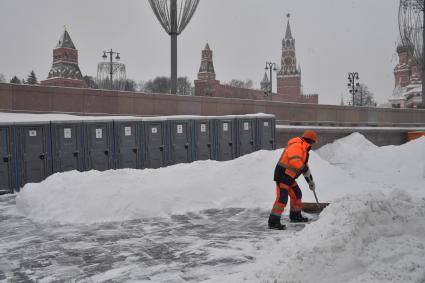 Москва. Сотрудник коммунальных служб расчищает снег в центре города.