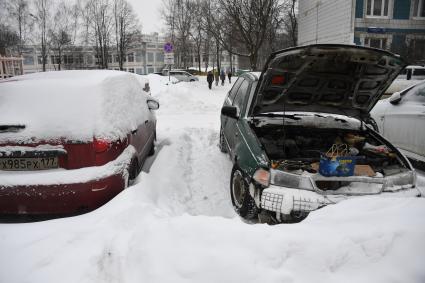 Москва.  Машина с открытым капотом во дворе.