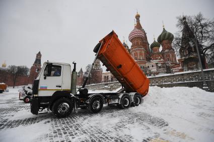 Москва. Самосвал выгружает снег на Васильевском спуске.