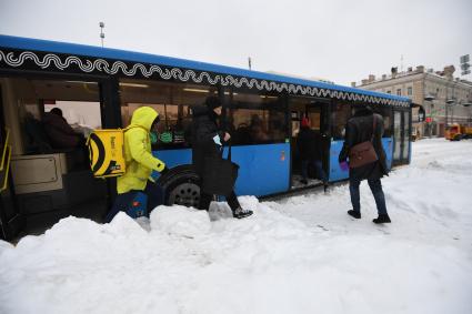 Москва. Пассажиры выходят из автобуса на заснеженной остановке.