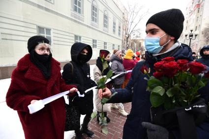 Москва. Юноша дарит розы участницам несогласованной акции `Цепь солидарности` на Старом Арбате.