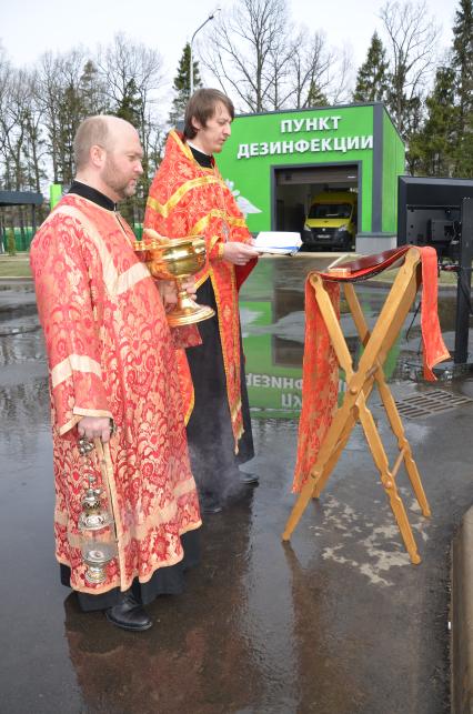 Москвовская область, г. Одинцово. Иерей храма преподобного Илии Муромца и великомученицы Варвары Артемий Попов окропляет территорию многофункционального медицинского центра на базе филиала военного госпиталя имени Вишневского.