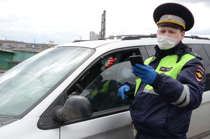 Москва. Инспектор ДПС проверяет цифровой пропуск у водителя в связи с введением дополнительных ограничений из-за распространения коронавируса COVID-19.