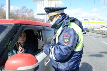 Москва. Инспектор ДПС проверяет цифровой пропуск у водителя в связи с введением дополнительных ограничений из-за распространения коронавируса COVID-19.