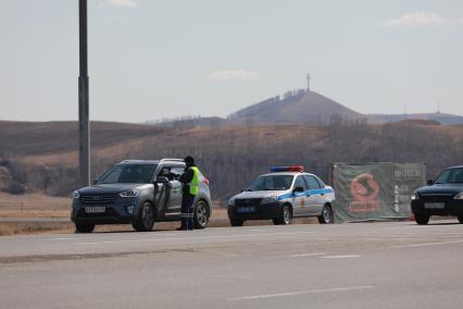 Красноярск. Сотрудник ДПС проверяет документы у водителя на въезде в город в связи с введением дополнительных ограничений из-за распространения коронавируса COVID-19.