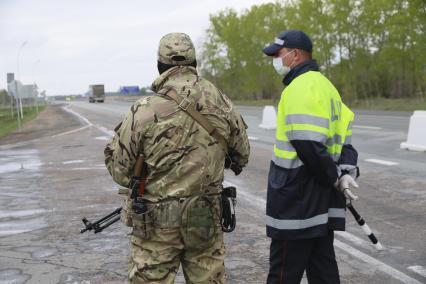 Барнаул. Сотрудники Росгвардии и ДПС во время проверки пропусков у водителей на выезде из города. С 1 мая действует пропускной режим в связи с введением ограничений из-за распространения COVID-19.