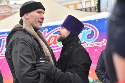 Москва. Члены исполкома Федерации бенди Николай Валуев и отец Даниил Зубов   во время гала-матча по хоккею с мячом между сборными командами артистов театра и кино `Комар` и Ассоциации любительского хоккея `А-линия`на ГУМ-катке на Красной площади  в рамках финального этапа   турнира на приз  Святейшего Патриарха Московского и всея Руси .

.