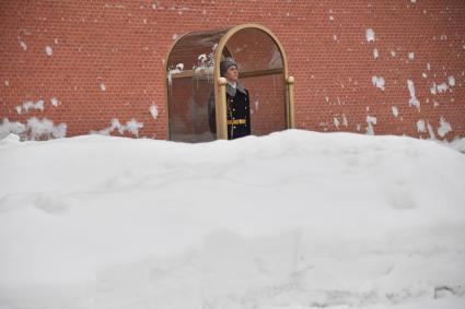 Москва.  Солдат роты почетного караула на посту  у Вечного огня на Могиле Неизвестного Солдата у Кремлевской стены в Александровском саду после сильного снегопада.