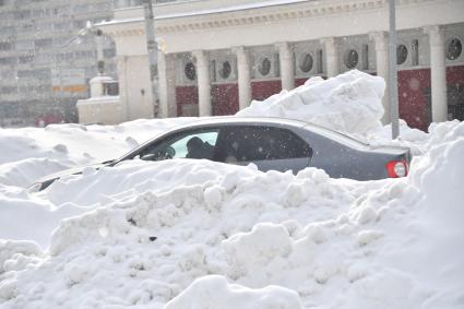 Москва.  Заснеженные автомобили на одной из улиц города.