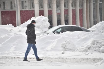 Москва.  Заснеженные автомобили на одной из улиц города.