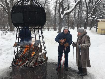 Москва. Горожане греются возле огня в парке Сокольники.