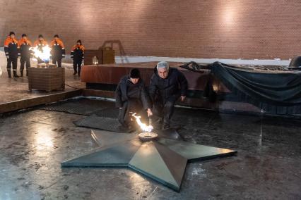 Москва. Сопредседатель Центрального штаба ОНФ, ответственный секретарь ООД Поисковое движение России Елена Цунаева и генеральный директор АО Мосгаз Гасан Гасангаджиев во время переноса пламени на горелку Вечного огня на Могиле Неизвестного Солдата в Александровском саду после профилактики.