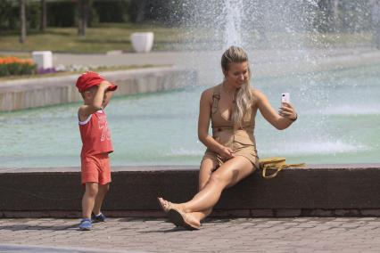 Барнаул. Девушка фотографируется у фонтана.