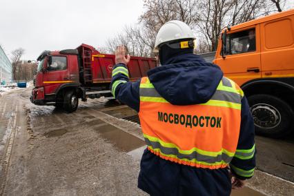 Москва. Сотрудник снегоплавильного пункта ГУП`Мосводосток`во время разгрузки грузовых автомобилей со снегом.