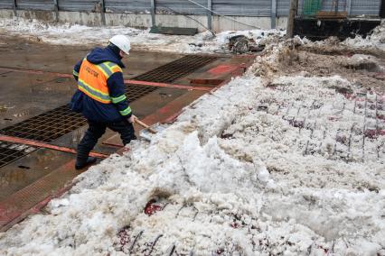 Москва. Сотрудник снегоплавильного пункта ГУП`Мосводосток`во время разгрузки грузовых автомобилей со снегом.