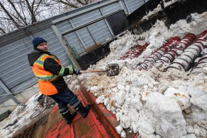 Москва. Сотрудник снегоплавильного пункта ГУП`Мосводосток`во время разгрузки грузовых автомобилей со снегом.