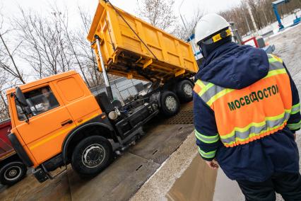 Москва. Сотрудник снегоплавильного пункта ГУП`Мосводосток`во время разгрузки грузовых автомобилей со снегом.