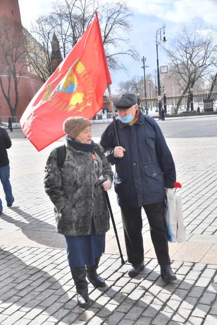 Москва.  Мужчина и женщина с флагом после церемонии возложения венков и цветов к месту захоронения Иосифа Виссарионовича Сталина у Кремлевской стены.