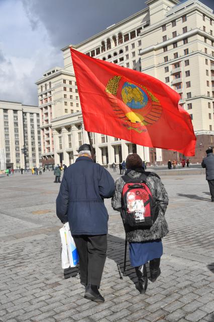 Москва.  Мужчина и женщина с флагом после церемонии возложения венков и цветов к месту захоронения Иосифа Виссарионовича Сталина у Кремлевской стены.