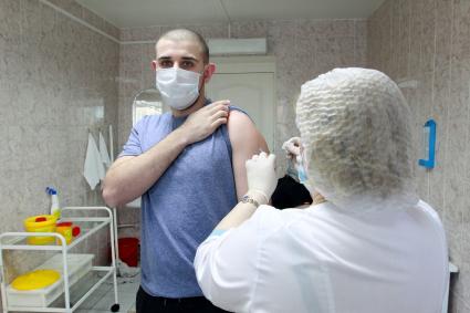 Иркутск. Медсестра делает мужчине прививку вакциной `Гам-Ковид-Вак` от коронавирусной инфекции в поликлинике.
