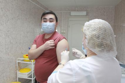 Иркутск. Медсестра делает мужчине прививку вакциной `Гам-Ковид-Вак` от коронавирусной инфекции в поликлинике.