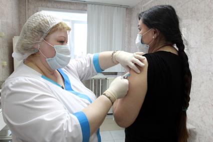 Иркутск. Медсестра делает женщине прививку вакциной `Гам-Ковид-Вак` от коронавирусной инфекции в поликлинике.