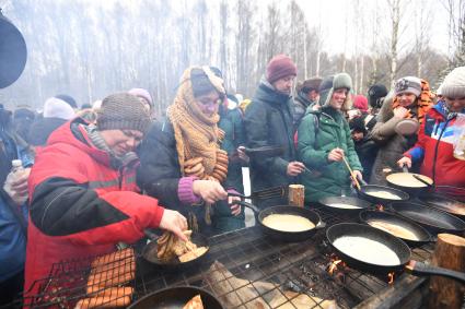 Московская область. Участники народных гуляний пекут блины на праздновании `Бакшевской Масляницы 2021` недалеко от железнодорожной станции Гжель.