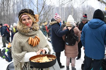 Московская область. Участники народных гуляний пекут блины на праздновании `Бакшевской Масляницы 2021` недалеко от железнодорожной станции Гжель.