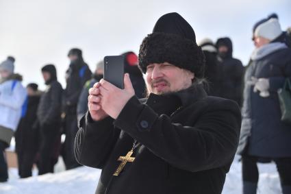 Нарьян-Мар. Священнослужитель фотографирует  на празднике весны и на соревнованиях по кроссу на снегоходах на Кубок Героя Советского Союза, Героя Российской Федерации Артура Чилингарова  `Буран-Дей`.