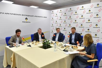 Москва. Начальник отдела инновационных проектов на шельфе `Арктического научного центра` Артем Исаченко, директор департамента научно-технического развития и инноваций ПАО `НК `Роснефть` Александр Пашали (слева направо), руководитель проекта стратиграфического бурения ООО `РН-Эксплорейшн` Андрей Колюбакин (второй справа) и ведущая Наталья Семенихина во время пресс-конференции на тему `Арктические экспедиции Роснефти` в ИД `Комсомольская правда`.