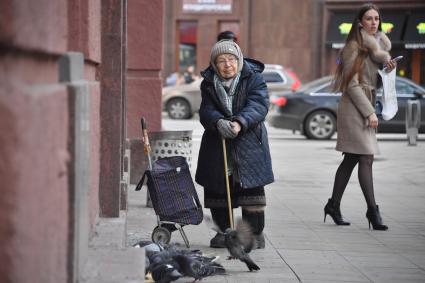 Москва. Пожилая женщина стоит на улице.