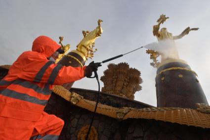 Москва. Работник `Гормоста` проводит промывку фонтана `Дружба народов` на ВДНХ.