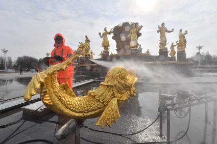 Москва. Работник `Гормоста` проводит промывку фонтана `Дружба народов` на ВДНХ.