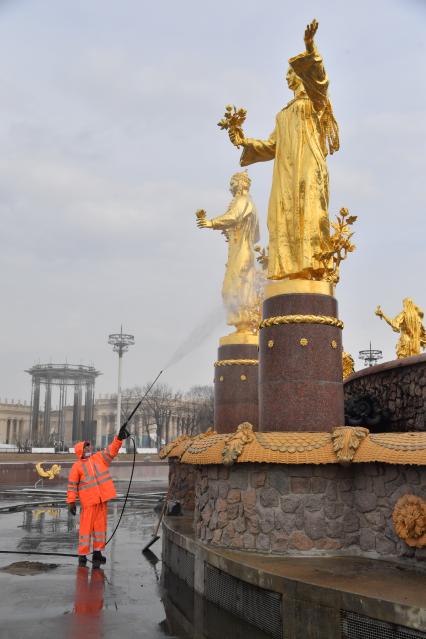 Москва. Работник `Гормоста` проводит промывку фонтана `Дружба народов` на ВДНХ.