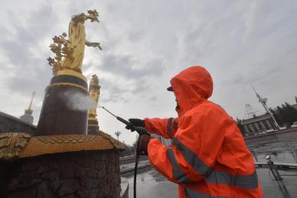 Москва. Работник `Гормоста` проводит промывку фонтана `Дружба народов` на ВДНХ.