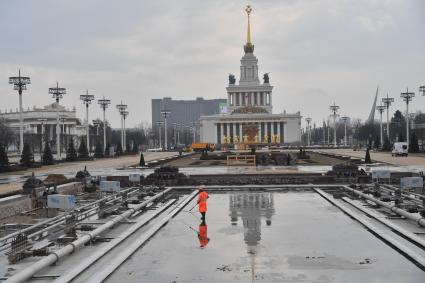 Москва. Работник `Гормоста` проводит уборочные работы перед запуском фонтана `Каменный цветок` на ВДНХ.