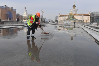 Москва. Работник `Гормоста` проводит уборочные работы перед запуском фонтана `Каменный цветок` на ВДНХ.