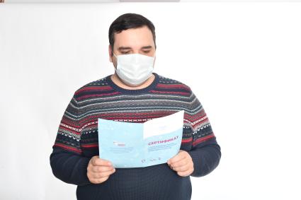 Москва. Мужчина демонстрирует сертификат о вакцинации против новой короновирусной инфекции COVID-19, полученный после прививки.