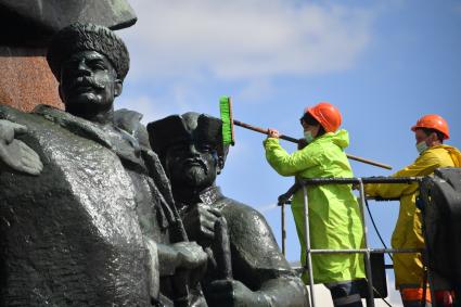 Москва. Работники коммунальных служб моют памятник В. И. Ленину на Калужской площади.