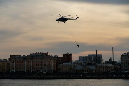 Санкт-Петербург. Вертолет Ми-8 с водосливным устройством ВСУ-5 во время тушения пожара в здании фабрики`Невская мануфактура`.