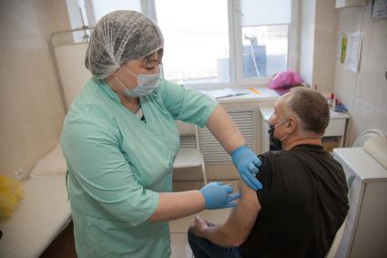 Пермь. Медсестра делает мужчине прививку вакциной `Гам-Ковид-Вак` от коронавирусной инфекции в поликлинике.