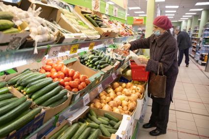 Пермь. Пенсионерка выбирает овощи в магазине `Пятерочка`.