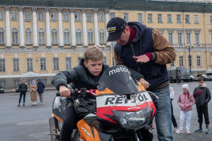 Санкт-Петербург. Мужчина с мальчиком перед началом мотопарада, посвященного открытию сезона, на Дворцовой площади.
