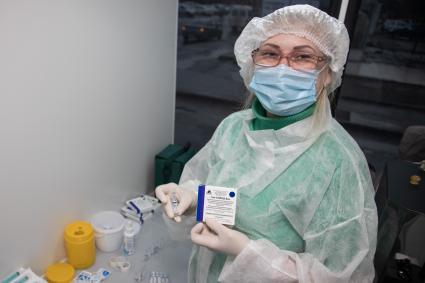 Пермь. Медсестра держит в руках вакцину `Гам-КОВИД-Вак` (`Спутник V`) от коронавирусной инфекции COVID-19  в мобильном  пункте вакцинации.