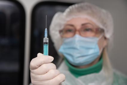 Пермь. Медсестра держит в руках шприц с вакциной `Гам-КОВИД-Вак` (`Спутник V`) от коронавирусной инфекции COVID-19  в мобильном  пункте вакцинации.