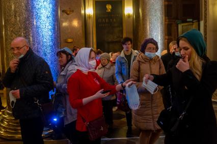 Санкт-Петербург. Женщина раздает защитные маски прихожанам на входе в Казанский кафедральный собор во время Пасхального богослужения.